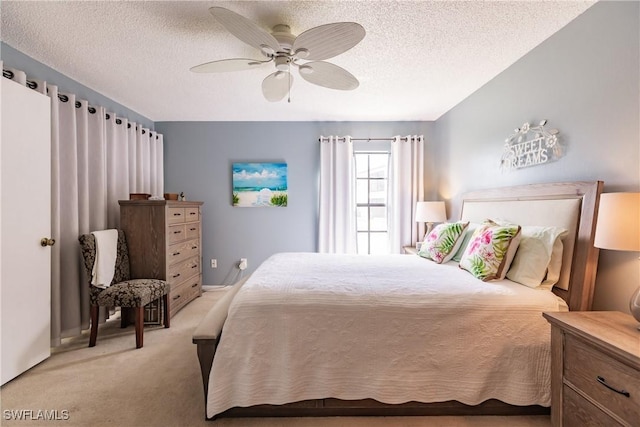 bedroom featuring a textured ceiling, a ceiling fan, and light colored carpet