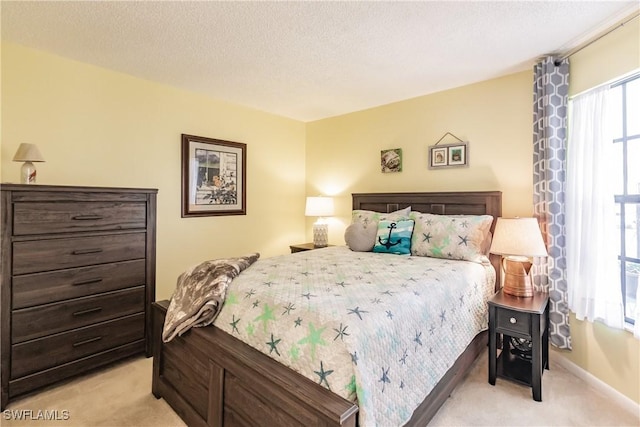 bedroom with a textured ceiling and light colored carpet