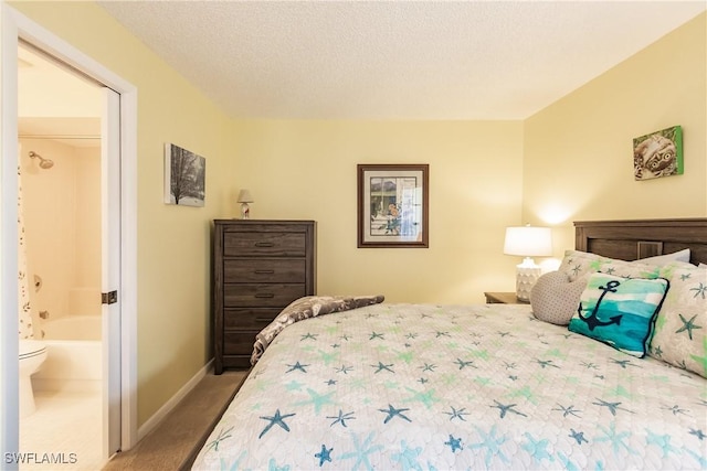 bedroom featuring carpet, ensuite bath, a textured ceiling, and baseboards