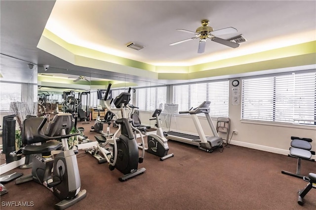 exercise room featuring visible vents, ceiling fan, and baseboards