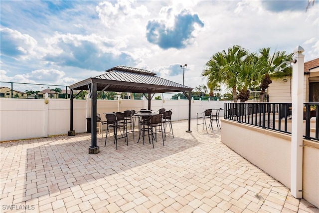 view of patio with a fenced backyard, outdoor dining area, and a gazebo