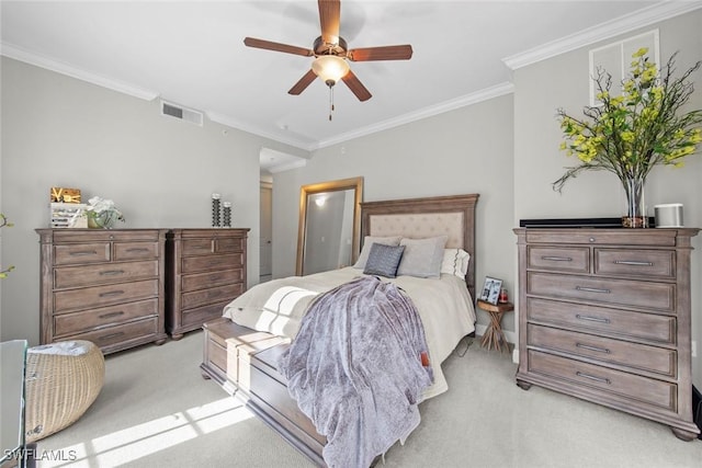 bedroom featuring ornamental molding, light colored carpet, ceiling fan, and visible vents