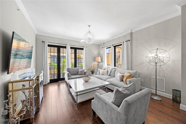 living area featuring a notable chandelier, visible vents, baseboards, ornamental molding, and dark wood finished floors