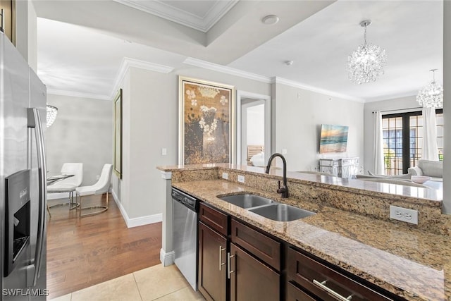 kitchen featuring appliances with stainless steel finishes, ornamental molding, hanging light fixtures, a chandelier, and a sink