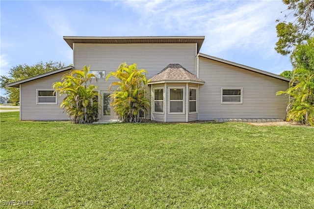 rear view of property with a yard