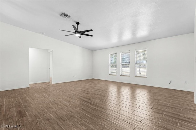 spare room with a ceiling fan, baseboards, visible vents, and wood finished floors