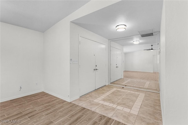 interior space with a ceiling fan, baseboards, and wood finished floors