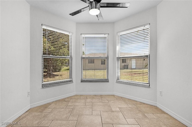 empty room with a ceiling fan and baseboards