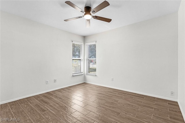 empty room featuring a ceiling fan, baseboards, and wood finished floors