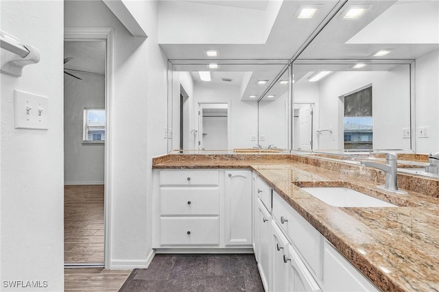 bathroom featuring wood finished floors, a sink, and double vanity