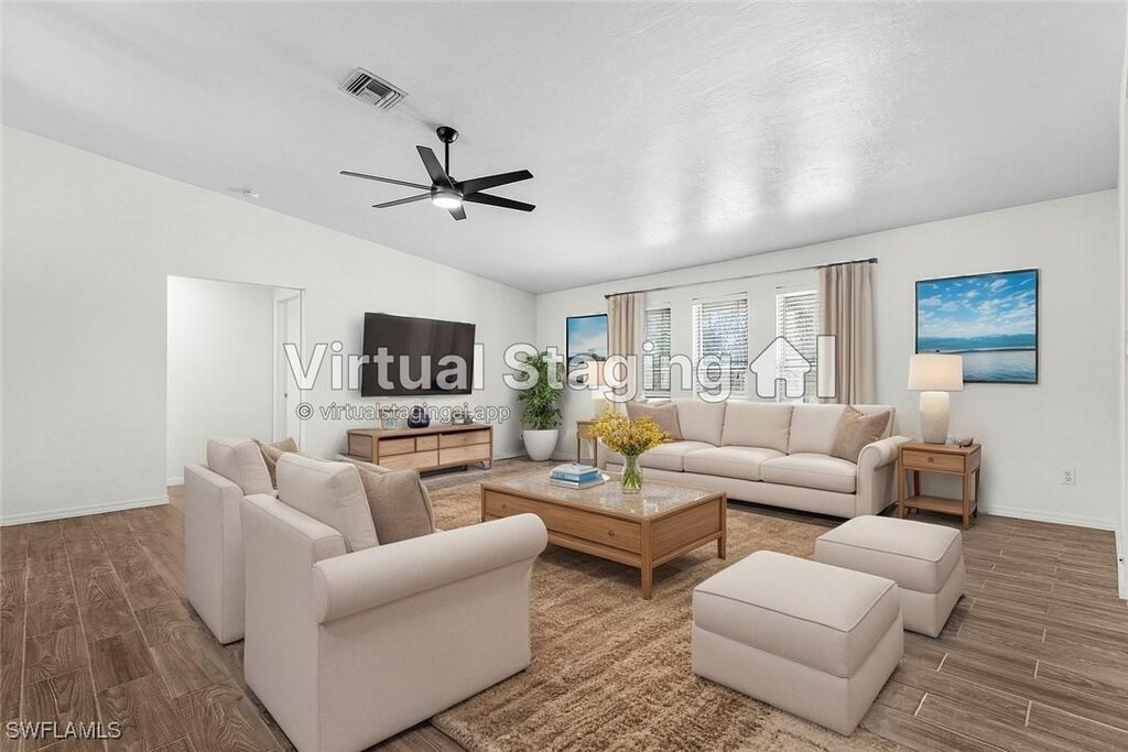 living room with baseboards, vaulted ceiling, visible vents, ceiling fan, and wood finished floors