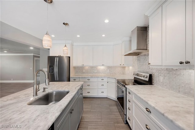 kitchen featuring decorative light fixtures, a sink, stainless steel appliances, wall chimney range hood, and backsplash