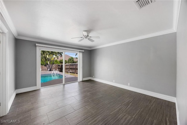 empty room featuring ornamental molding, visible vents, and baseboards