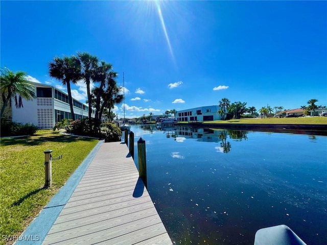 view of dock featuring a water view and a lawn