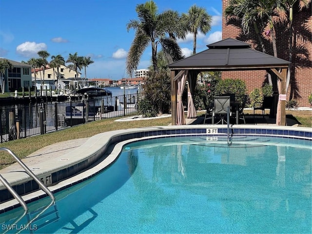 pool with a gazebo, a patio area, fence, and a water view