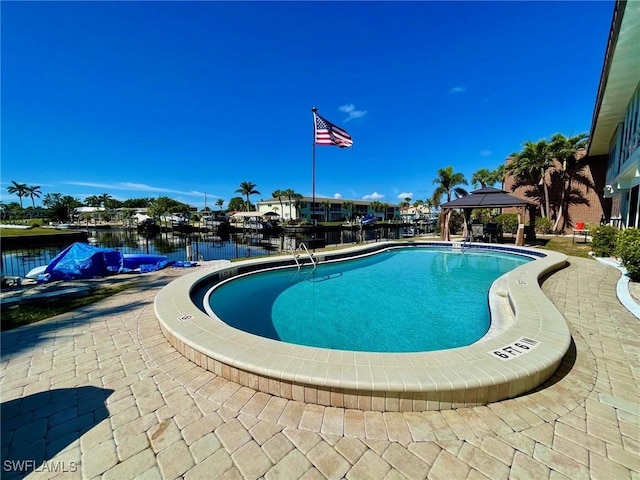 view of swimming pool with a patio area, a gazebo, and a water view