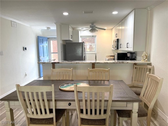 kitchen featuring visible vents, ceiling fan, light stone counters, stainless steel appliances, and white cabinetry