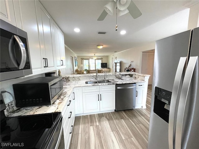 kitchen with stainless steel appliances, a sink, visible vents, and white cabinets