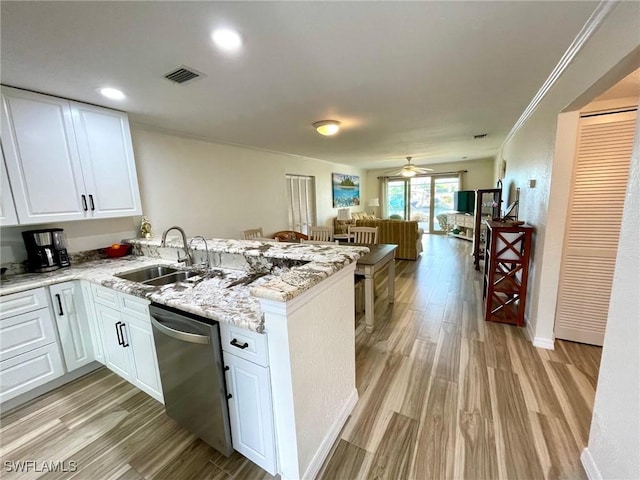 kitchen with open floor plan, a sink, light wood-type flooring, dishwasher, and a peninsula