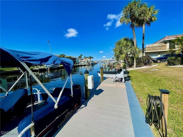 dock area with a water view and a yard