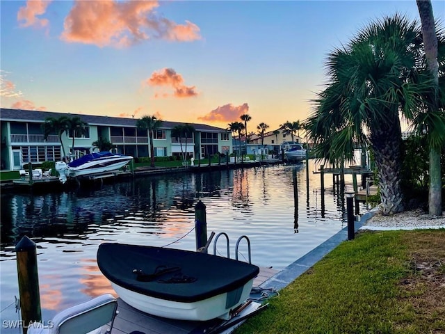 dock area with a water view, a residential view, and a yard