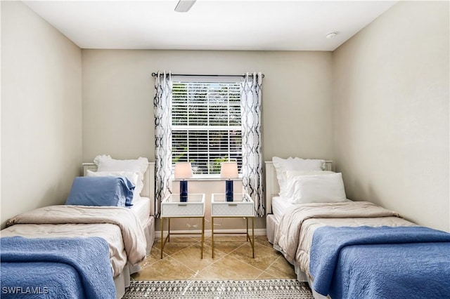 bedroom featuring light tile patterned floors, a ceiling fan, and baseboards