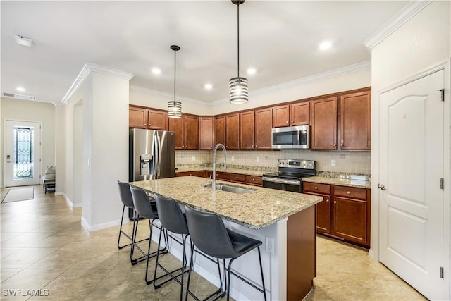 kitchen with light stone counters, stainless steel appliances, a breakfast bar, a sink, and decorative backsplash