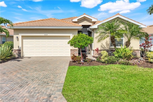 view of front of house with stone siding, a front lawn, decorative driveway, and stucco siding