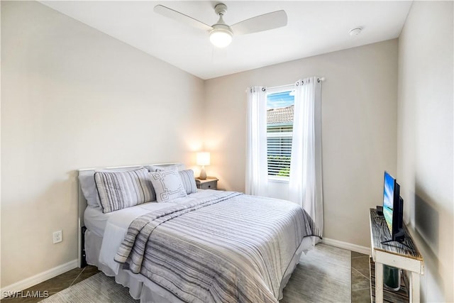 bedroom with a ceiling fan, baseboards, and tile patterned floors