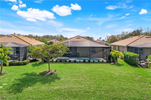 rear view of property with a yard, a lanai, a tile roof, and an outdoor pool