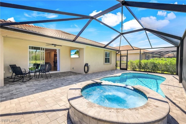 view of pool featuring a ceiling fan, a pool with connected hot tub, a patio, and a lanai