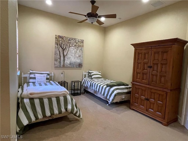 bedroom featuring visible vents, light colored carpet, and a ceiling fan