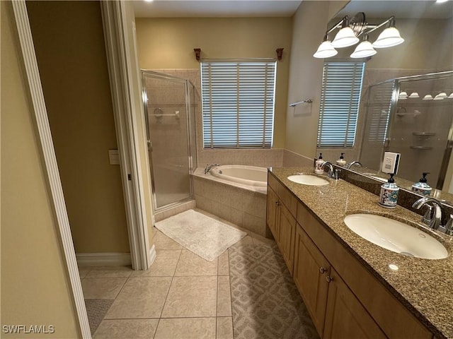 bathroom featuring tile patterned flooring, a shower stall, a bath, and a sink