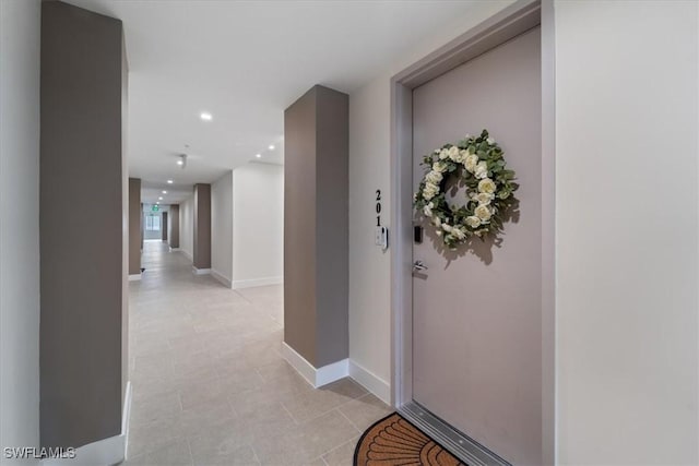 corridor featuring recessed lighting and baseboards