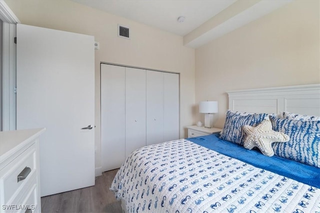 bedroom featuring a closet, visible vents, and wood finished floors