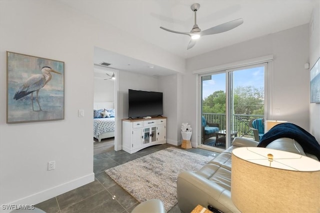 living area featuring visible vents, ceiling fan, dark tile patterned floors, and baseboards