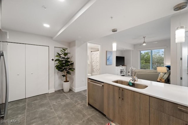 kitchen with dishwasher, open floor plan, decorative light fixtures, light countertops, and a sink