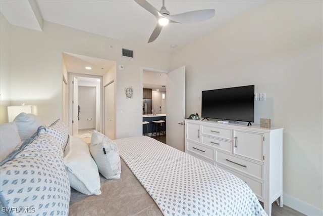 bedroom featuring visible vents, ceiling fan, ensuite bath, stainless steel fridge, and baseboards