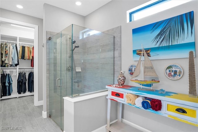 bathroom with a shower stall, a spacious closet, and recessed lighting