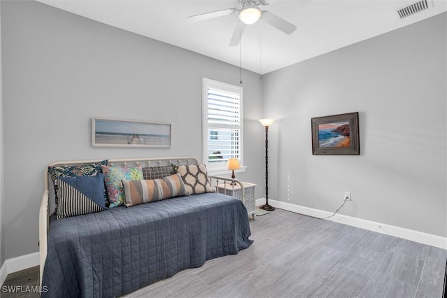 bedroom with wood finished floors, visible vents, and baseboards