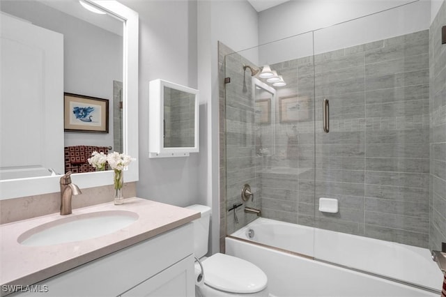 bathroom with toilet, shower / bath combination with glass door, and vanity