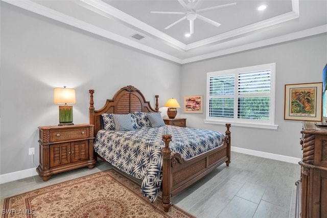 bedroom with baseboards, a raised ceiling, visible vents, and crown molding