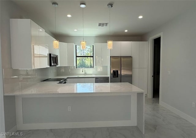 kitchen featuring marble finish floor, appliances with stainless steel finishes, backsplash, and a sink