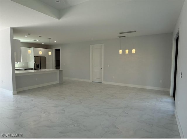 unfurnished living room featuring marble finish floor, recessed lighting, and baseboards