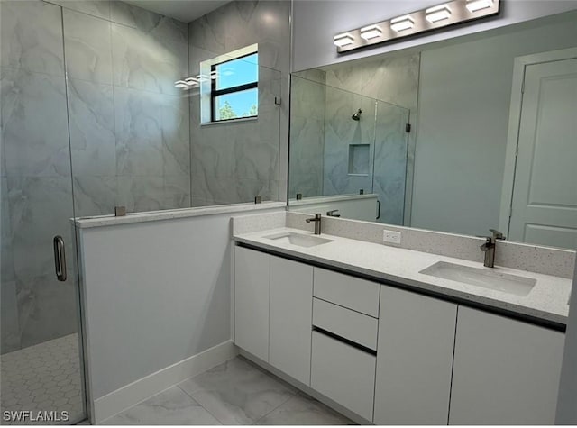 full bath with marble finish floor, a sink, and a stall shower