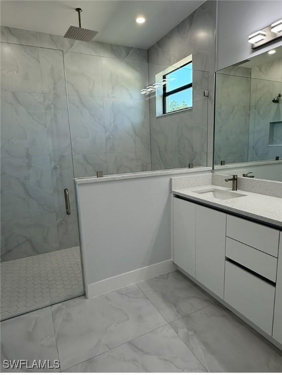 bathroom with recessed lighting, marble finish floor, vanity, and a marble finish shower