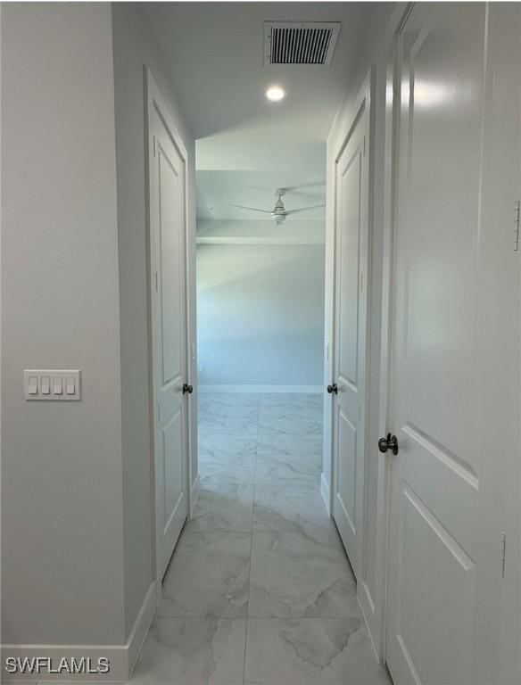 corridor featuring marble finish floor, visible vents, and baseboards