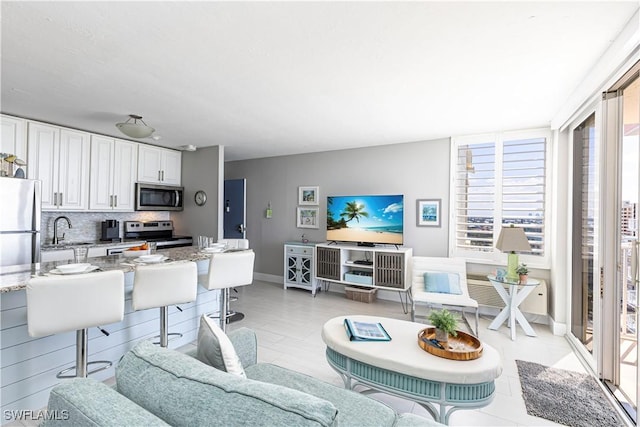 living room featuring light tile patterned floors and baseboards