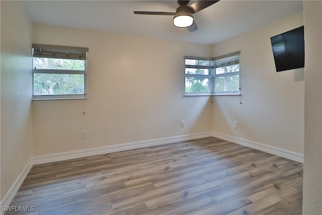 unfurnished room featuring ceiling fan, wood finished floors, and baseboards