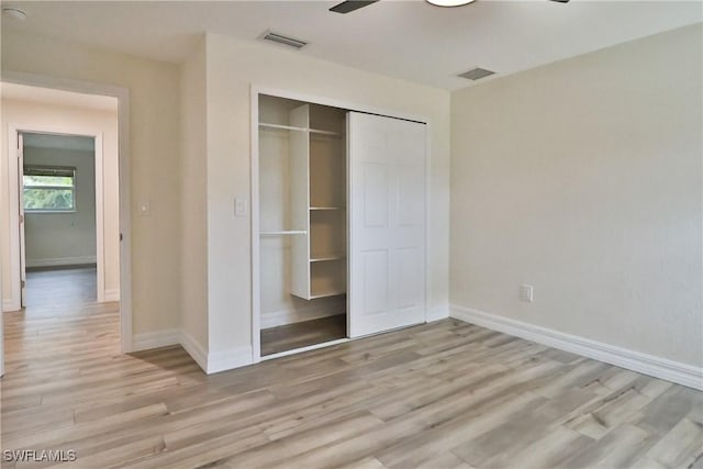 unfurnished bedroom featuring light wood finished floors, a closet, visible vents, and baseboards